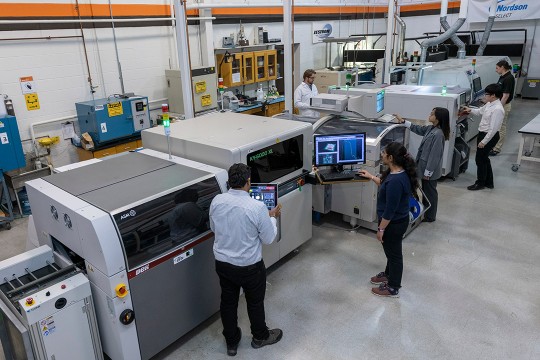 engineering lab with large electronics assembly machinery.