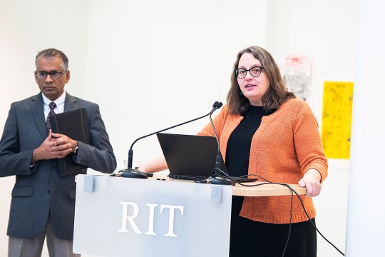 dean speaking at a podium.