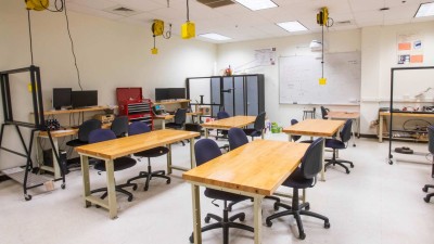 Class room with four tables and outlets accessible from the ceiling