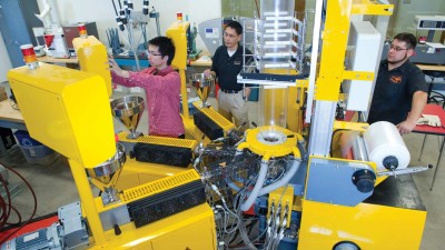 Three people calibrating a large machine