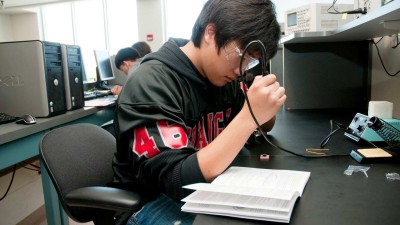 Student soldering at a work station
