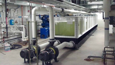 Large container filled with liquid and large pipes running the length over the top