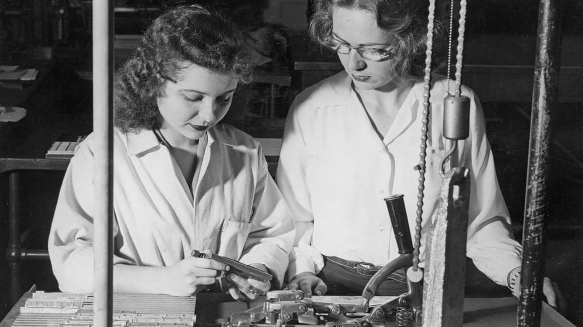 Two women working with type.