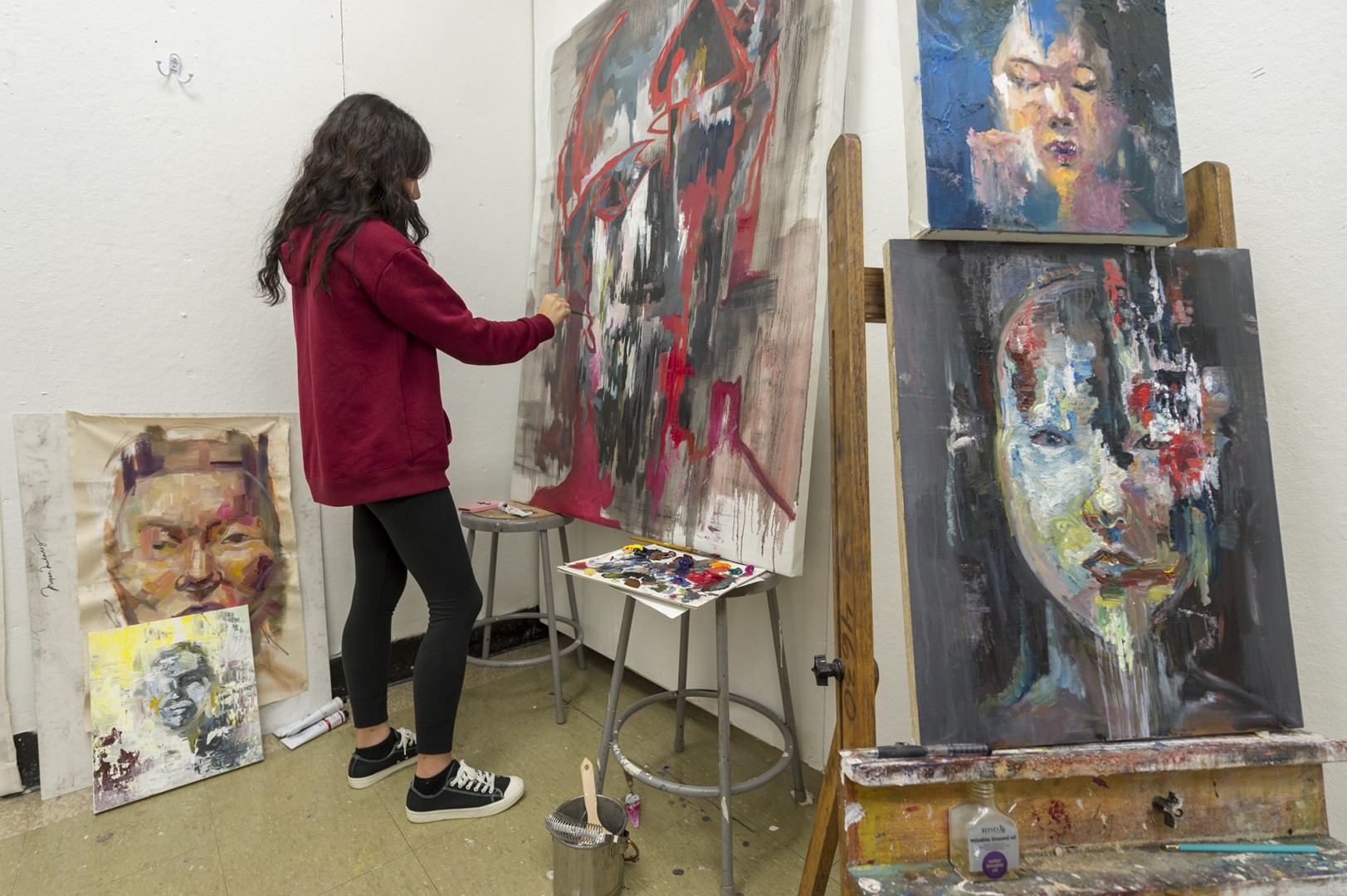 A student paints in a studio.