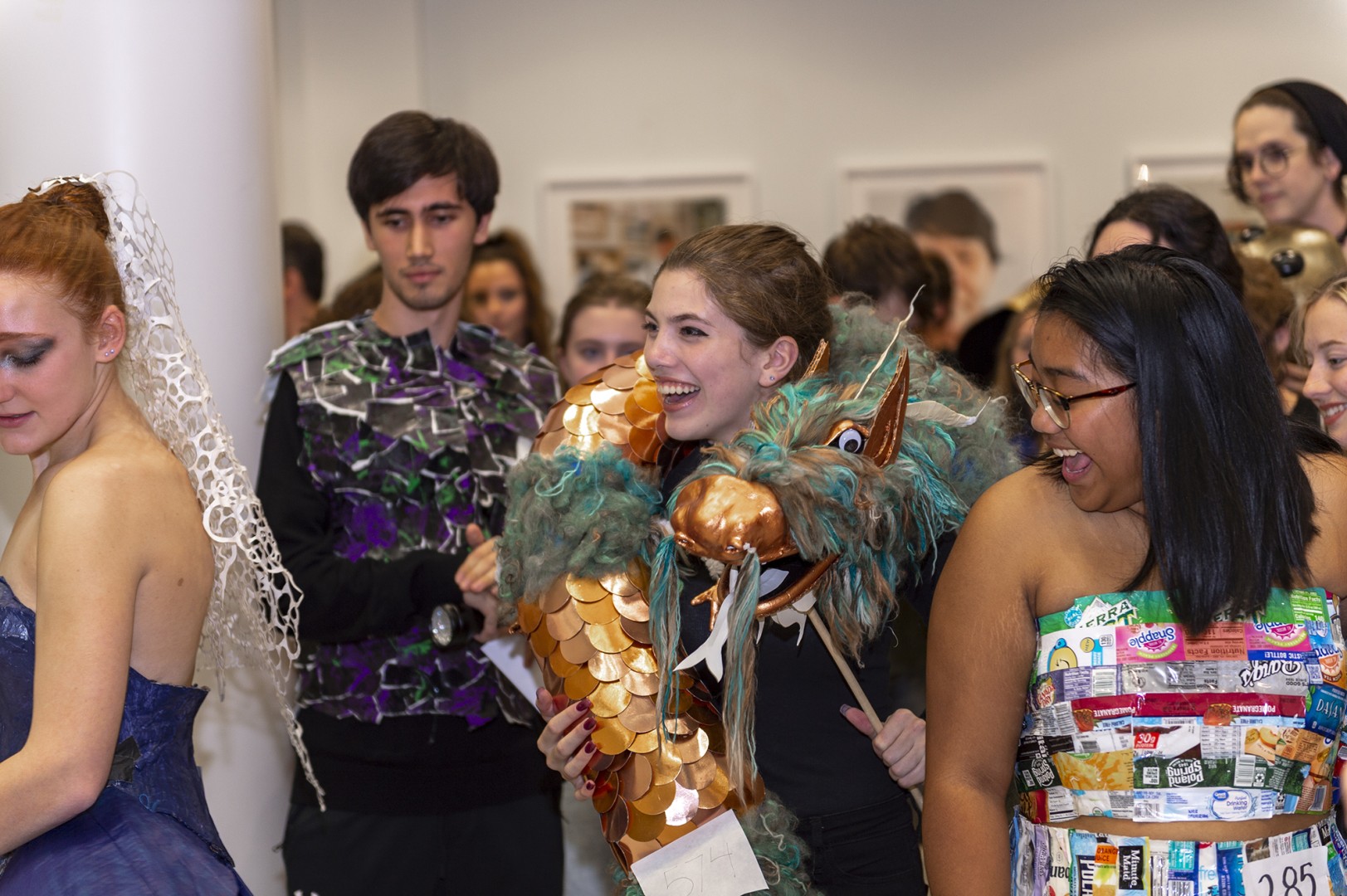 Students don wearable sculpture during a reception event.