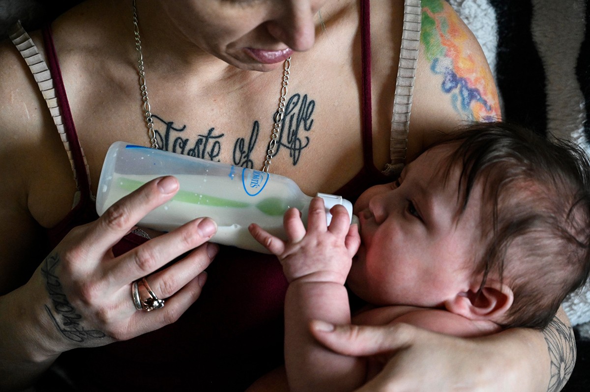 A woman feeds her baby.