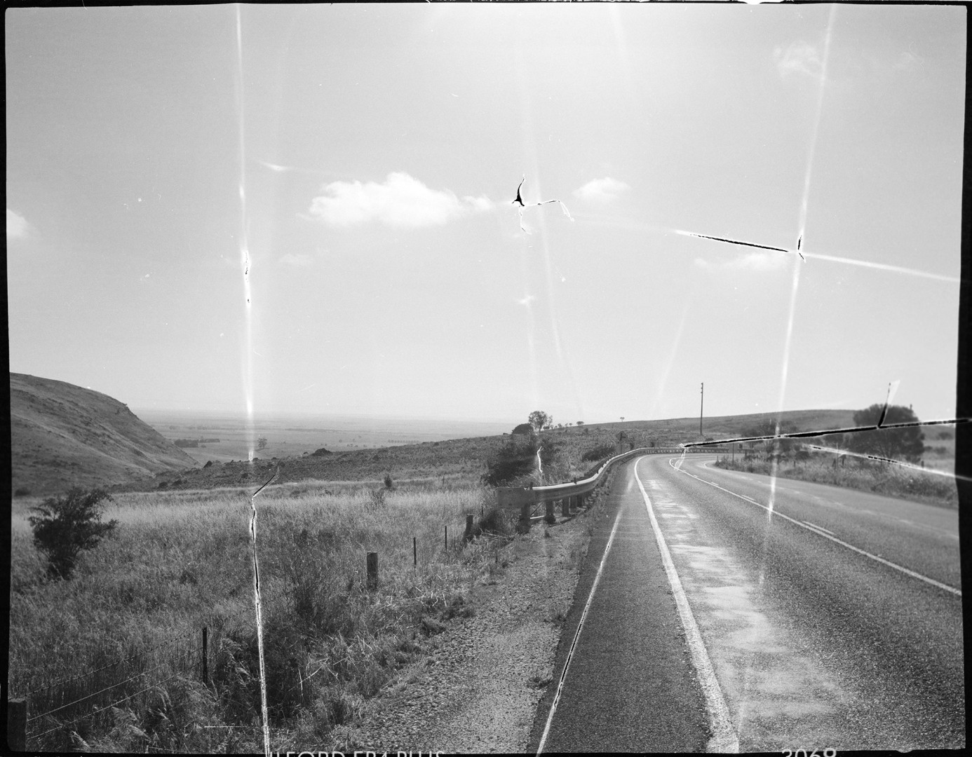 A black-and-white photo of a country road.