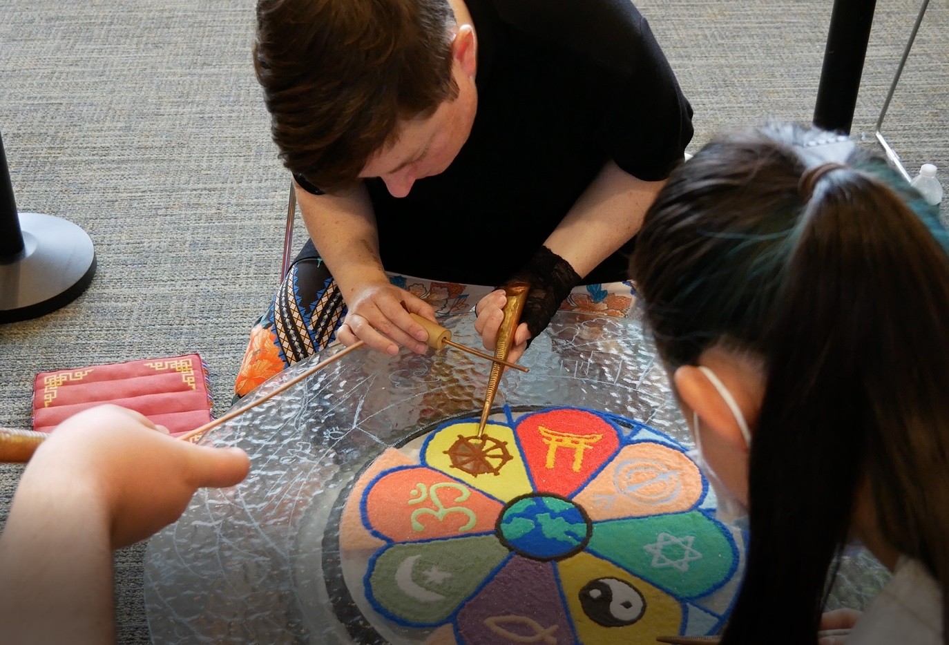 Rev. Katie Jo Suddaby and students creating interfaith sand mandala