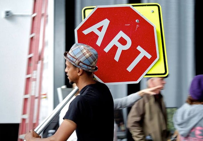 Shawn Dunwoody holding a stop sign that says ART.