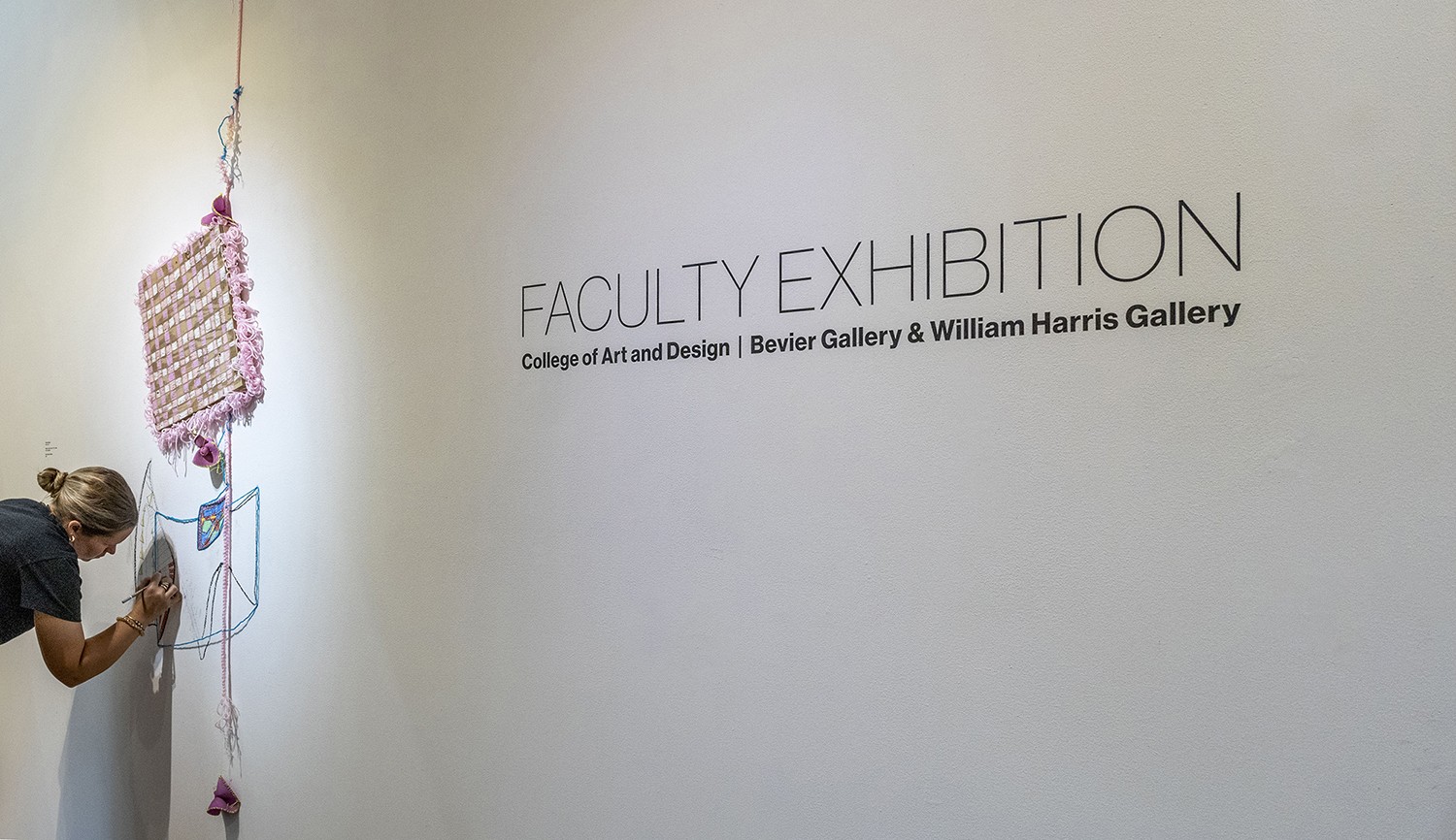 Faculty Exhibition on the wall in Bevier Gallery.