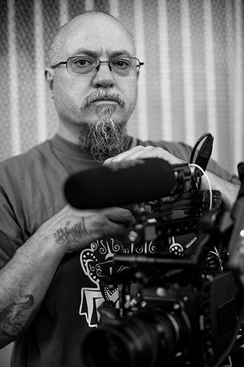 Estevan Oriol with hands resting on a camera.