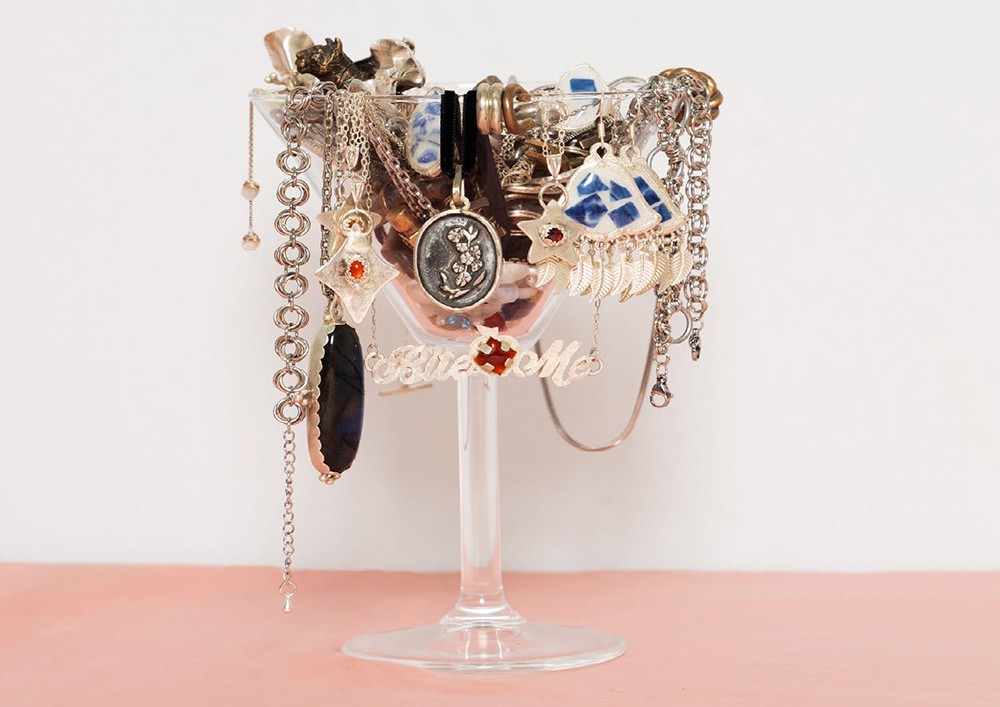 A cup draped in jewelry.