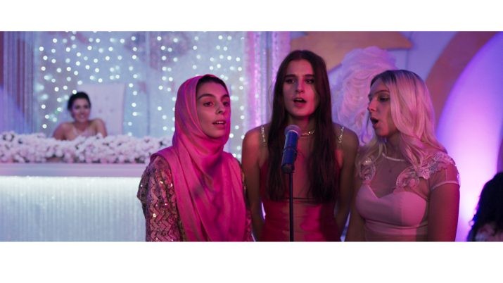 Three women are shown in a split-screen composition under pink and purple lighting, each appearing to sing. The woman on the left wears a headscarf, the center woman sings into a microphone, and the woman on the right has long blonde hair. Large yellow text reading “SONNE” overlays the bottom of the image.