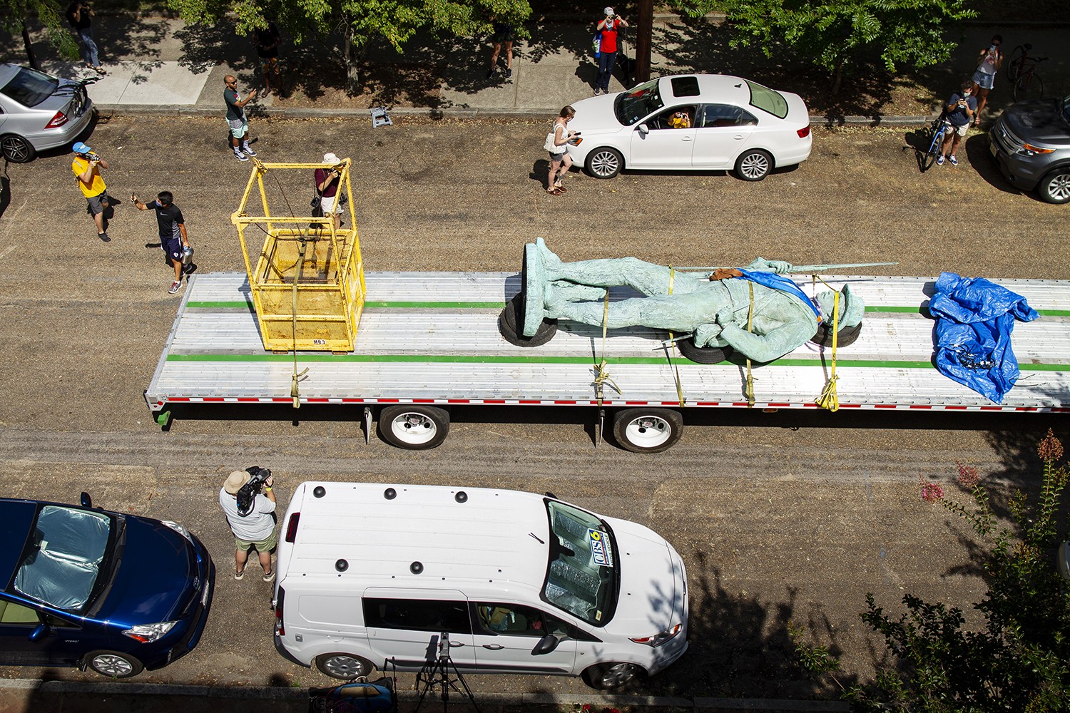 An overhead photo of a truck driving away with a torn-down statue.