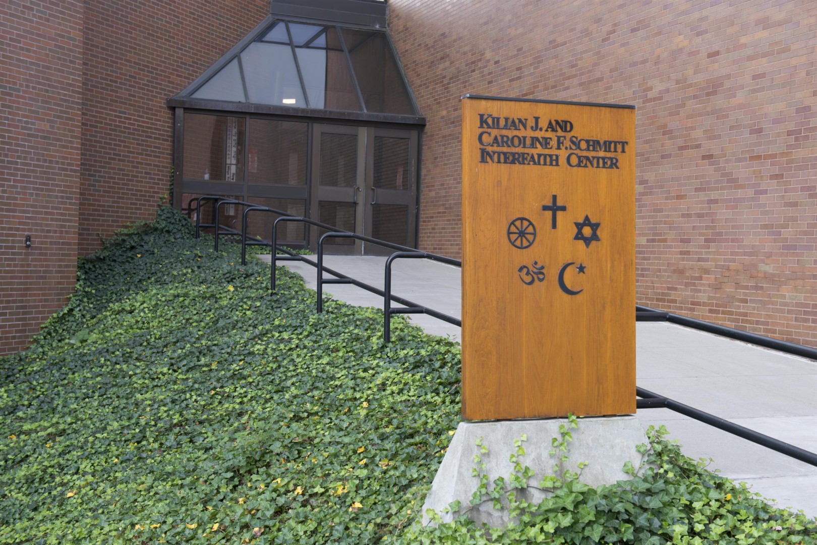 Quarter Mile walkway entrance into Schmitt Interfaith Center with sign and spiritual symbols