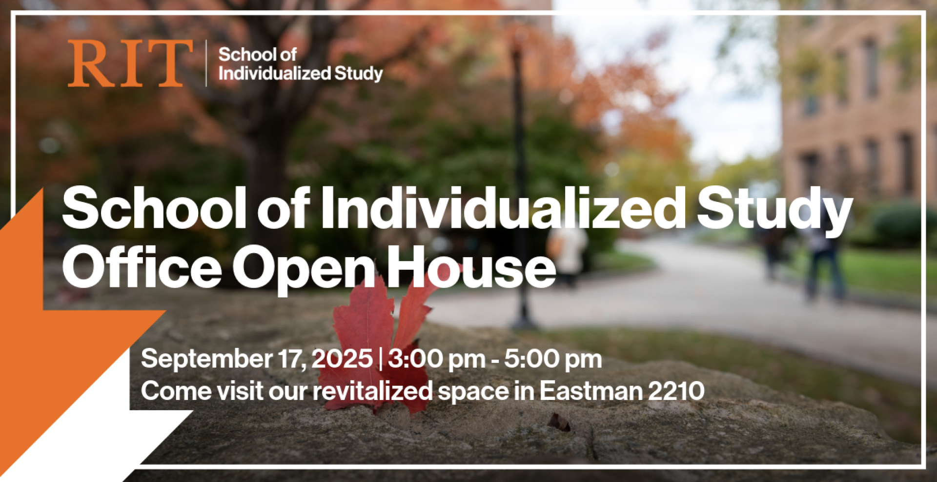 RIT Eastman Hall in the background of a fall day and a red maple leaf sitting on a stone wall
