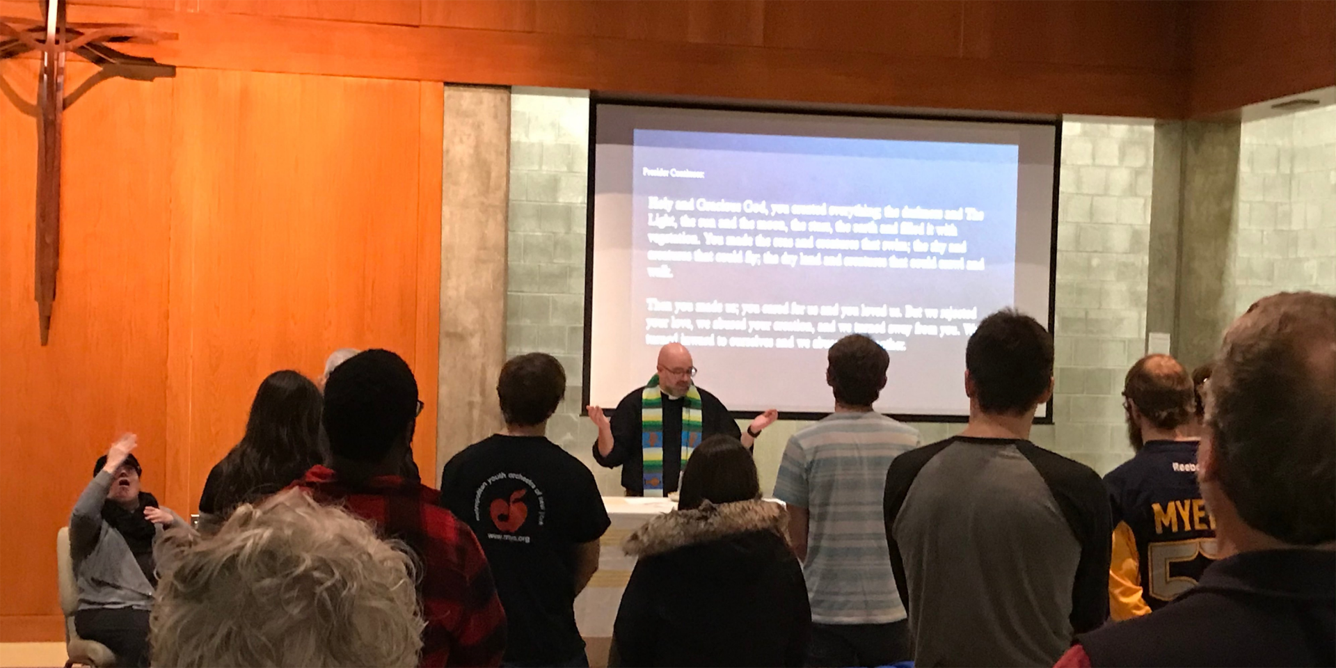 A photo of a group of people joining in a chapel for worship. 