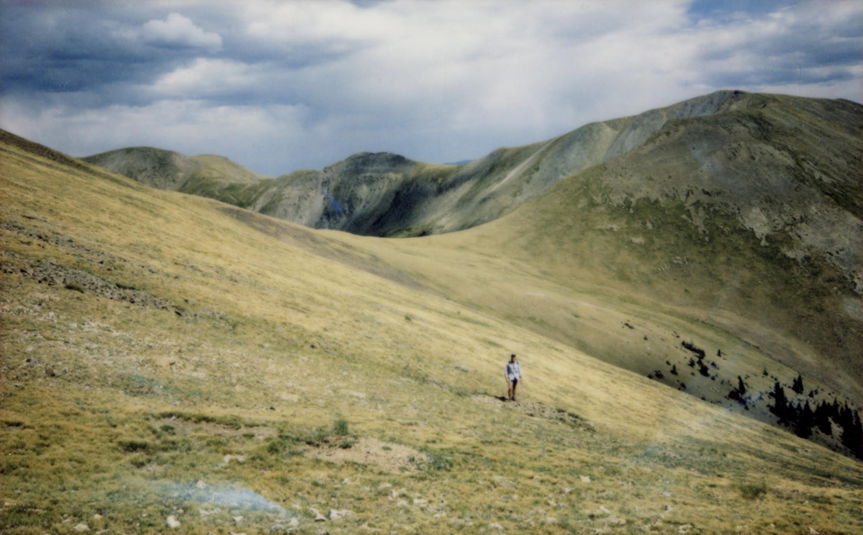 A photo illustration of a person walking in a wide-open, large field.
