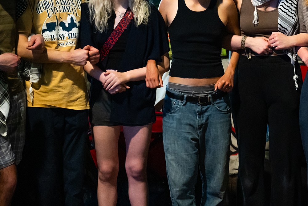 A row of people, shown from the neck down.