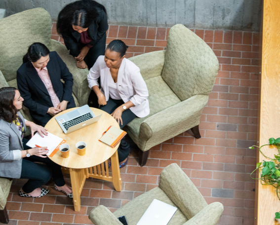 4 people working around a table  overhead view