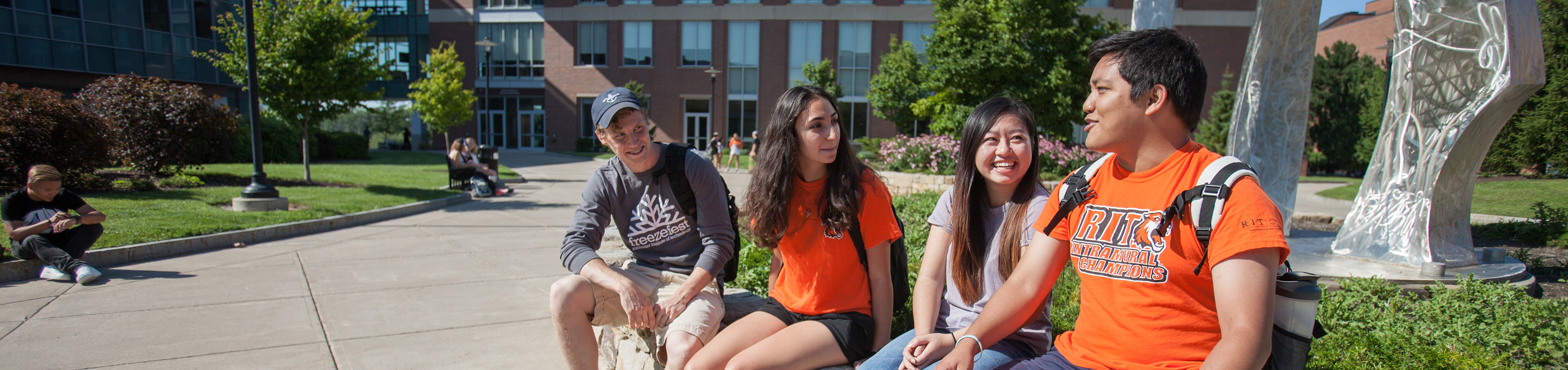 4 diverse students hanging out in Infinity Quad.