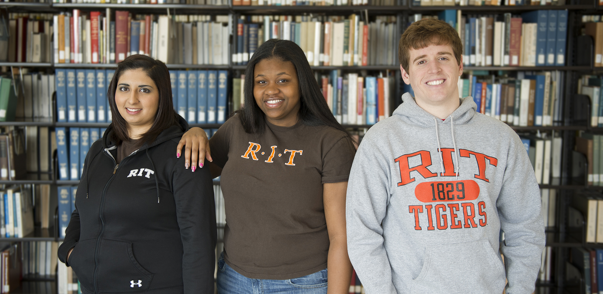 A portrait of three RIT students in the library.