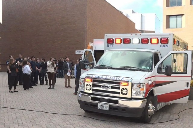 people gather around an ambulance on the R I T campus