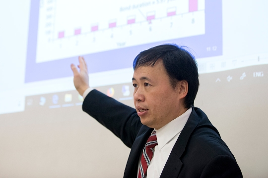 Professor points to presentation on screen.