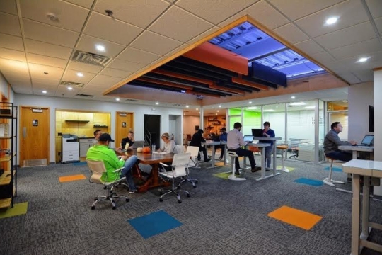 People work at desks in colorful office space.