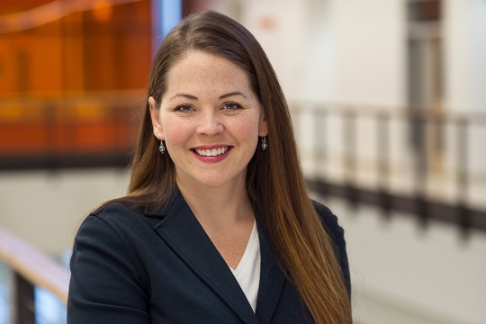 Head-and-shoulders view of woman wearing navy blazer.