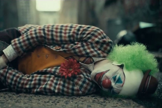 Screenshot from "Joker" movie with clown laying on the ground.