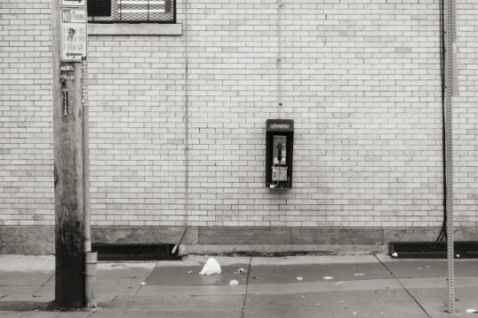 Payphone on a brick wall.