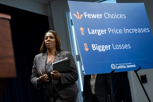 woman walking behind poster that reads: Fewer choices, larger price increases, bigger losses.