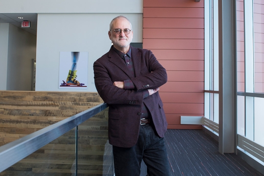 man standing in opem second-floor landing area.
