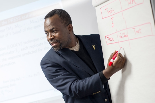 professor writing on giant notepad.