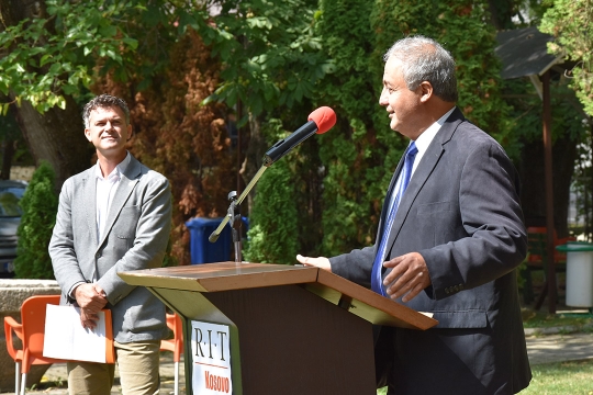 RIT Kosovo president speaking at podium outdoors.