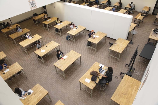 Overhead view of students at tables set up in former gallery space.