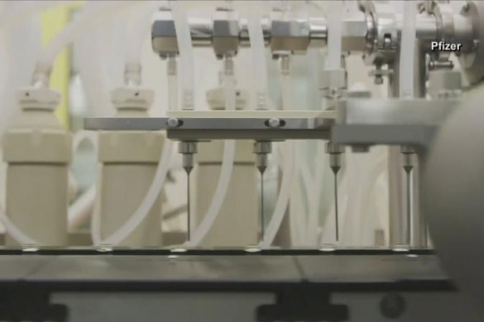 machine filling vials with vaccine.