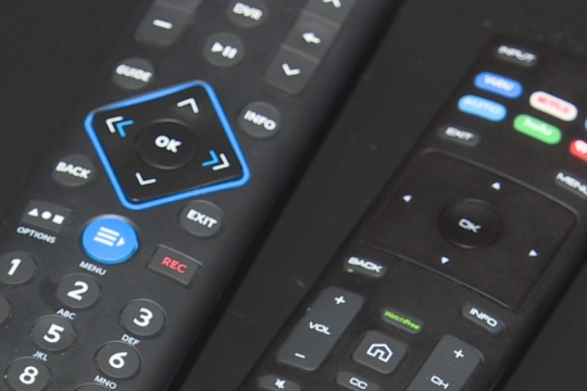 closeup of two TV remotes.