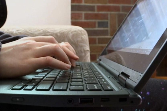 hands typing on laptop.