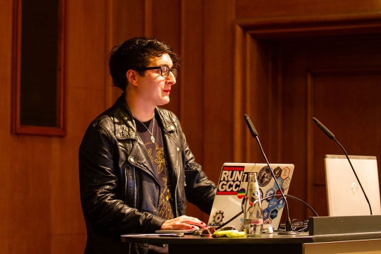 person standing at a podium with a laptop.