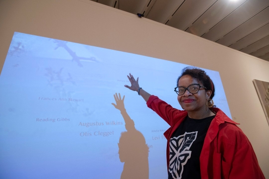professor standing in front of an interactive digital memorial.