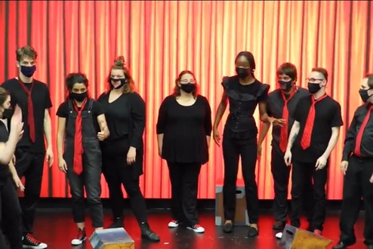student performers standing on stage.