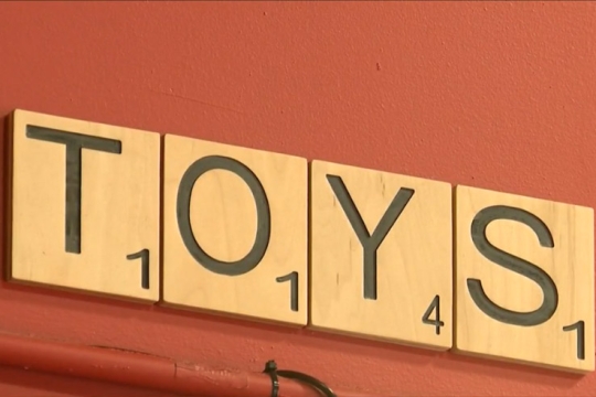 sign spelling T, O, Y, S with what looks like Scrabble tiles.