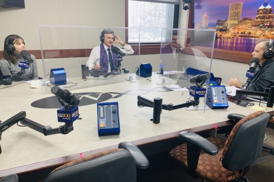 three people talking in a radio station studio.