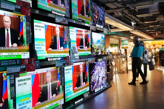 several TVs showing Russian president Vladimir Putin on a Chinese news station.