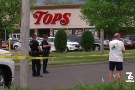 a screenshot of a TV news story showing a Tops supermarket with police tape.