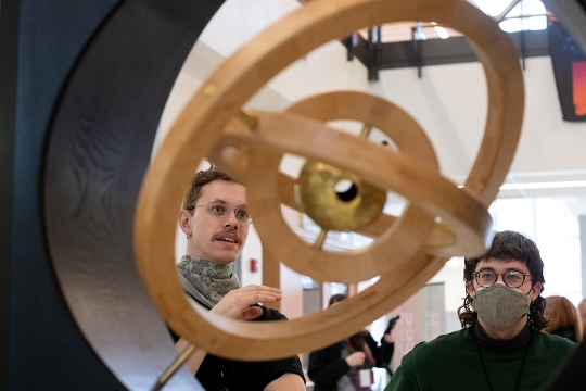 two people looking at a sculpture with three concentric circles.
