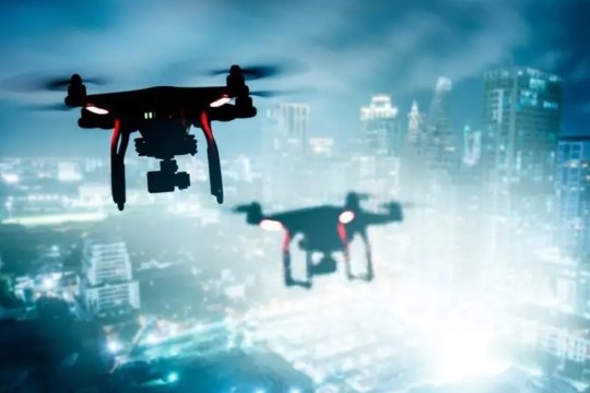 Two drones flying over a city