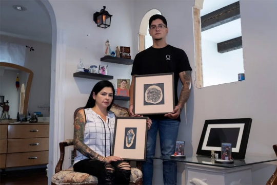 a man and a woman each holding framed tattoos.